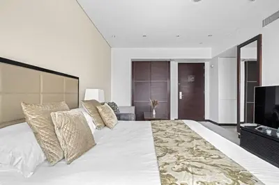 a bedroom with a large white bed and a television at Amazing 1 Bd Marina View LLC in Dubai