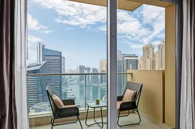 a balcony with chairs and a table and a view of the city at Amazing 1 Bd Marina View LLC in Dubai