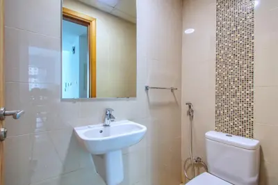 a bathroom with a sink and a toilet and a mirror at ShoresInn - Cozy 1BHK in Dubai Marina in Dubai