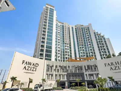 a large building in front of a parking lot at Stunning Studio w Pool & Gym in Dubai