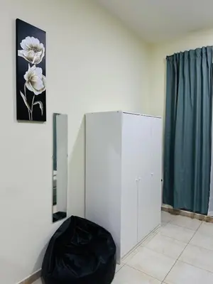 a room with a white cabinet and a flower picture at Bright Spacious Apartment in Dubai Sports City in Dubai