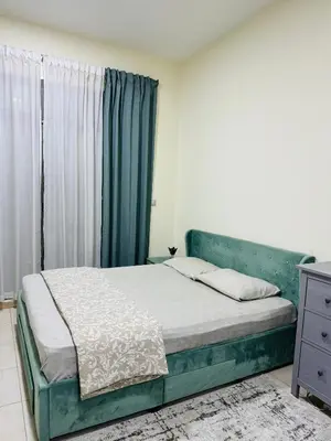 a bedroom with a green bed with a window at Bright Spacious Apartment in Dubai Sports City in Dubai