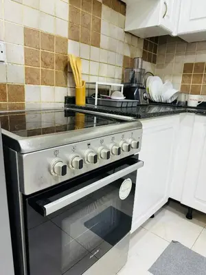 a kitchen with a stove top oven in a kitchen at Bright Spacious Apartment in Dubai Sports City in Dubai