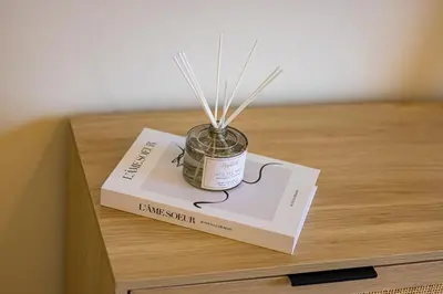 a book and a jar on top of a table at Daniels 2BR at Rimal JBR with Marina View in Dubai