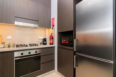 a kitchen with a stainless steel refrigerator and a stove at Elite Escape - 1 BHK Getaway Dubai Mall Access - 1509 in Dubai