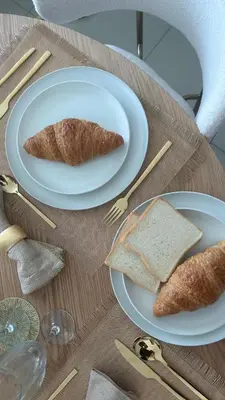 a table with two plates of food with bread and toast at Noma Fairview - Burj Khalifa view stunning apartment in Business Bay in Dubai