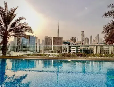 a large swimming pool with a city in the background at Noma Fairview - Burj Khalifa view stunning apartment in Business Bay in Dubai