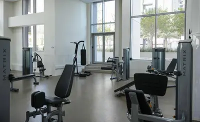 a gym with treadmills and chairs in a room with windows at Fabulous Canal Views Al Habtoor City in Dubai