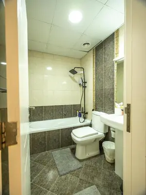a bathroom with a toilet and a tub and a sink at Luxury two bedrooms with Jbr and Marina view apartment in Dubai