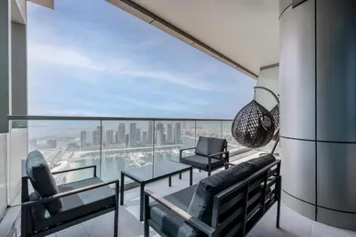 a balcony with two chairs and a glass table at The Luxe Marina Experience - Stylish 2BR with Sweeping Balcony Views for Total Relaxation in Dubai