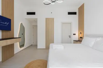 a bedroom with a large white bed and a tv at The Luxe Marina Experience - Stylish 2BR with Sweeping Balcony Views for Total Relaxation in Dubai