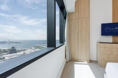 a room with a window with a view of the ocean at The Luxe Marina Experience - Stylish 2BR with Sweeping Balcony Views for Total Relaxation in Dubai