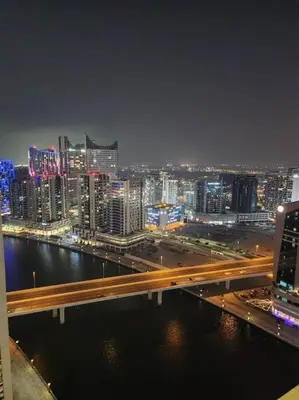 a view of a city at night with a bridge at LeModCasa - Modern Chic studio in Dubai