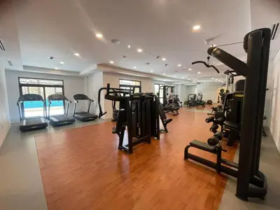 a gym with treadmills and machines in a room at 1BD Partial Burj Al Arab View Prime Location in Dubai
