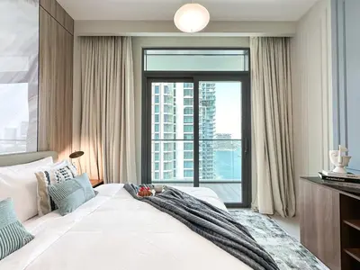 a bedroom with a large bed with a large window at Trophy - 1BR Beachfront Retreat w Lagoon Views in Dubai