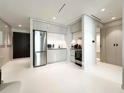 a kitchen with a stainless steel refrigerator at Trophy Luxury 1BDR in Emaar Beach Front with Panoramic Sea Views from the Apartment and Private Beach Access in Dubai
