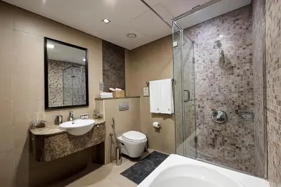 a bathroom with a sink and a toilet and a shower at Blueground DIFC marina view pool gym DXB-21 in Dubai