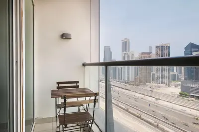 a balcony with a table and a view of the city at Blueground DIFC swimming pool gym security DXB-1545 in Dubai