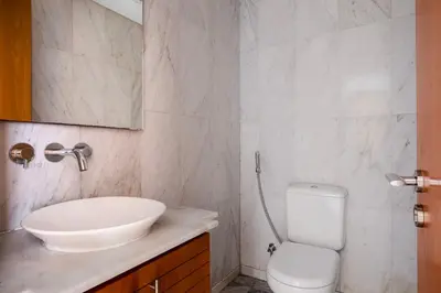 a bathroom with a white sink and a toilet at Blueground DIFC swimming pool gym security DXB-1545 in Dubai