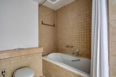 a bathroom with a bath tub and a toilet at Blueground The Residences gym parking DXB-1348 in Dubai