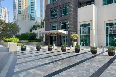 a building with potted plants in front of it at Blueground The Residences gym parking DXB-1348 in Dubai