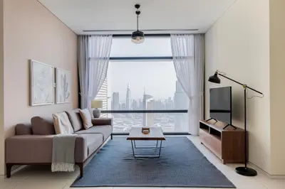 a living room with a couch and a large window at Blueground DIFC Burj K views indoor pool DXB-1493 in Dubai