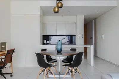 a dining room with a table and chairs in a kitchen at Blueground DIFC Burj K views indoor pool DXB-1493 in Dubai