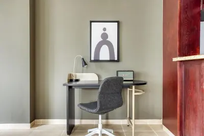 a desk with a chair and a phone at Blueground Burj Residences BK view pool gym DXB-1131 in Dubai
