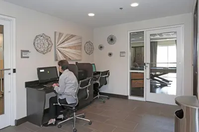 a woman sitting at a desk with a laptop in an office at Blueground Burj Residences BK view pool gym DXB-1131 in Dubai