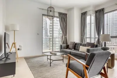 a living room with a couch and a tv at Blueground Burj Residences BK view pool gym DXB-1131 in Dubai