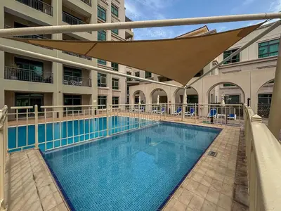 a large swimming pool with an umbrella in a building at Frank Porter - Arno A in Dubai