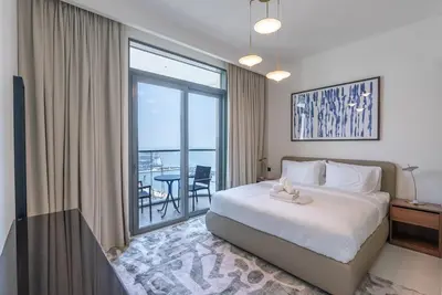 a bedroom with a bed and a large window at Beachfront Holiday 1BR Sea Marina Views in Dubai