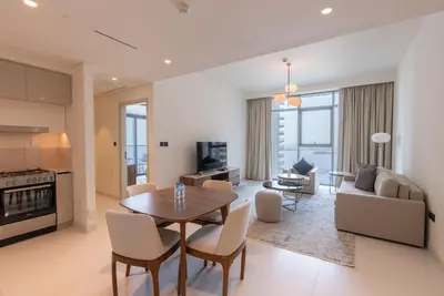 a living room with a table and chairs and a couch at Beachfront Holiday 1BR Sea Marina Views in Dubai