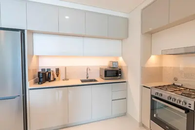 a kitchen with white cabinets and a stove top oven at Beachfront Holiday 1BR Sea Marina Views in Dubai