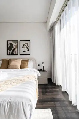 a white bedroom with a bed and a window at Stylish 1BR with Dubai Skyline & Burj Khalifa View in Dubai