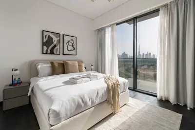 a white bedroom with a large bed and a large window at Stylish 1BR with Dubai Skyline & Burj Khalifa View in Dubai