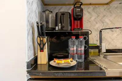 a kitchen counter with a plate of food and water bottles at Nice studio in JVT - Al Manara Tower - Dubai in Dubai