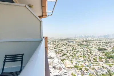 a chair sitting on the side of a balcony with a city at Nice studio in JVT - Al Manara Tower - Dubai in Dubai
