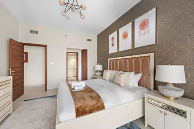 a bedroom with a large bed and a dresser at Brand New 2 Br Apartment In Family Community in Dubai