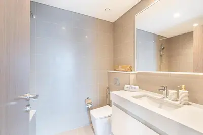a bathroom with a toilet and a sink and a mirror at Luxury Home on the 50th Floor with Full Burj View in Dubai