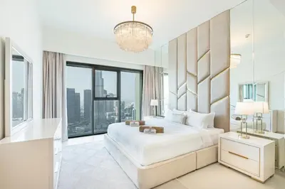 a white bedroom with a large bed and a large window at Luxury Home on the 50th Floor with Full Burj View in Dubai