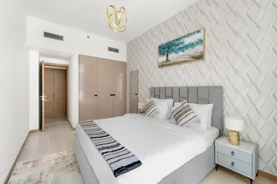 a bedroom with a large white bed with a night stand at ALiving Classy 1BR I Near Burj Khalifa & Dubai Mall I Missoni Tower- 211 in Dubai