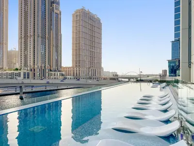 a row of white chairs in a pool in a city at ALiving Classy 1BR I Near Burj Khalifa & Dubai Mall I Missoni Tower- 211 in Dubai