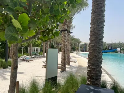 a resort with palm trees and a swimming pool at Creekside Bliss 1BR with Beach Access Summer 3 in Dubai