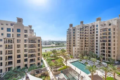an aerial view of two large buildings and a swimming pool at A Living One 1BR Apartment At Asayel 3, Madinat Jumeirah in Dubai