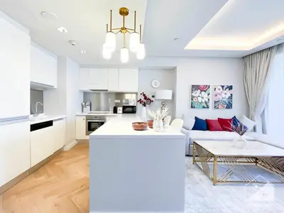 a white kitchen and living room with a couch at Dubai Mall Downtown Luxury stay with Balcony & View in Dubai
