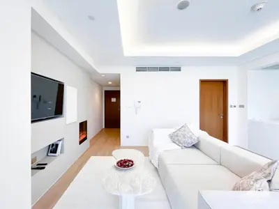 a white living room with a white couch and a table at Dubai Mall Downtown Luxury stay with Balcony & View in Dubai