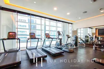 a gym with treadmills and ellipticals in a building at LUX The Bonnington JLT Suite 2 in Dubai