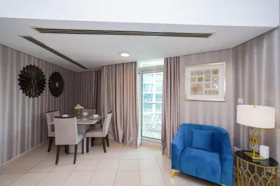 a dining room with a table and a blue chair at Lovely 1BHK in Burj views tower near Dubai mall in Dubai