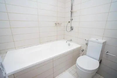 a white bathroom with a tub and a toilet at Lovely 1BHK in Burj views tower near Dubai mall in Dubai